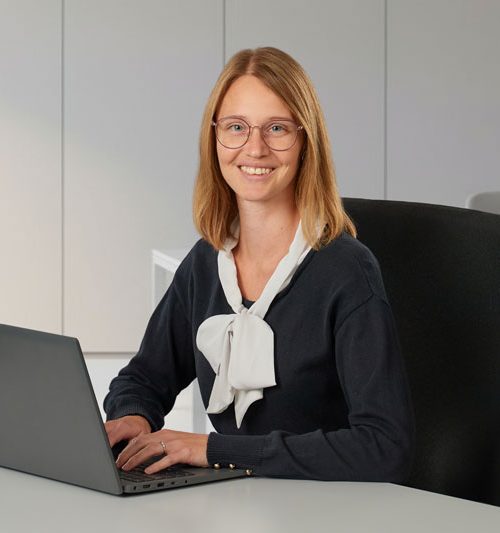 Frau Hölldobler im Business-Outfit am Schreibtisch arbeitend am Laptop