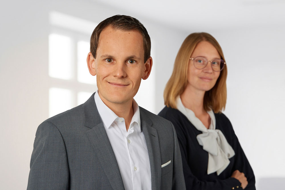 Portrait - Herr und Frau Hölldobler im Business-Outfit, stehend nebeneinander